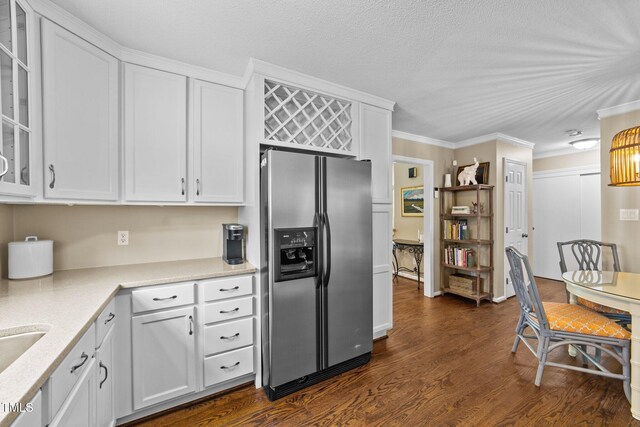 1033 Mills St, Raleigh, NC 27608 - kitchen featuring stainless steel fridge with ice dispenser, white cabinets, dark wood-style floors, glass insert cabinets, and ornamental molding