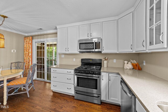 1033 Mills St, Raleigh, NC 27608 - kitchen with stainless steel appliances, white cabinetry, glass insert cabinets, dark wood-style flooring, and ornamental molding