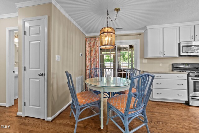 1033 Mills St, Raleigh, NC 27608 - dining room with crown molding, wood finished floors, and a chandelier