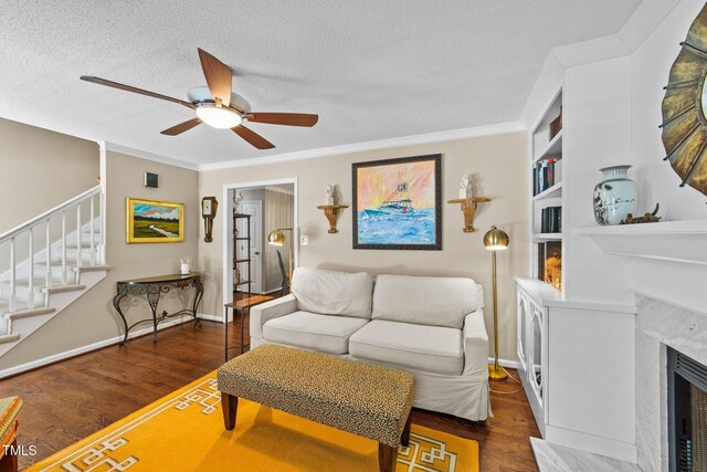 1033 Mills St, Raleigh, NC 27608 - living room featuring a ceiling fan, stairway, wood finished floors, a premium fireplace, and a textured ceiling