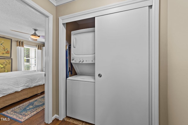 1033 Mills St, Raleigh, NC 27608 - washroom featuring stacked washing machine and dryer, wood finished floors, and crown molding