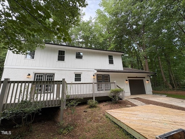 1300 Seabrook Ave, Cary, NC 27511 - rear view of house with brick siding, driveway, a garage, and a wooden deck