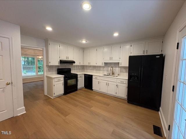 1300 Seabrook Ave, Cary, NC 27511 - kitchen with black appliances, under cabinet range hood, light countertops, white cabinetry, and recessed lighting