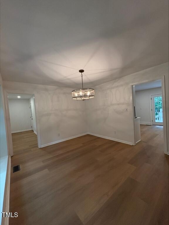 1300 Seabrook Ave, Cary, NC 27511 - unfurnished dining area with wood finished floors and a chandelier