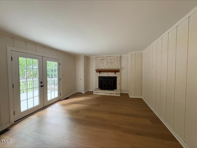 1300 Seabrook Ave, Cary, NC 27511 - unfurnished living room featuring french doors, light wood finished floors, and a fireplace
