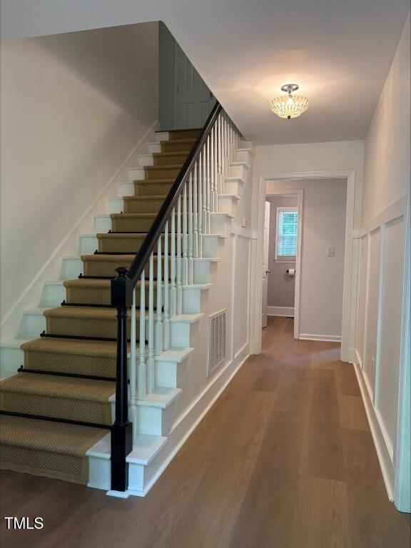 1300 Seabrook Ave, Cary, NC 27511 - staircase with wood finished floors and a chandelier