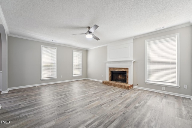 105 Leacroft Way, Durham, NC 27703 - unfurnished living room with a ceiling fan, ornamental molding, a brick fireplace, wood finished floors, and a textured ceiling