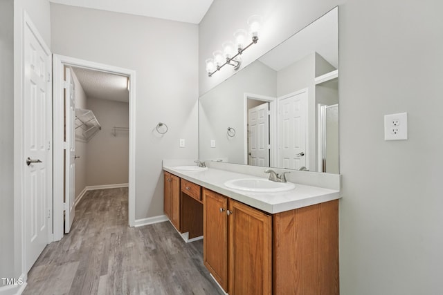 105 Leacroft Way, Durham, NC 27703 - bathroom with double vanity, wood finished floors, a shower with shower door, and a spacious closet