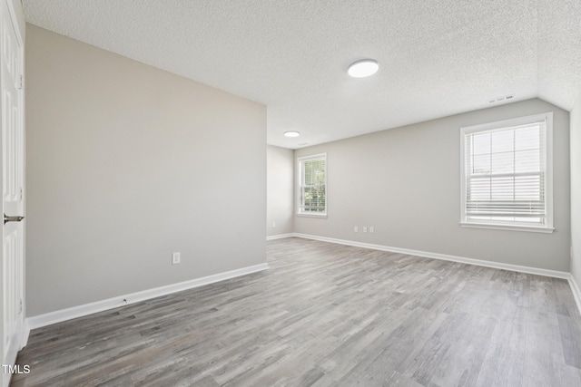 105 Leacroft Way, Durham, NC 27703 - spare room with wood finished floors, a textured ceiling, and lofted ceiling