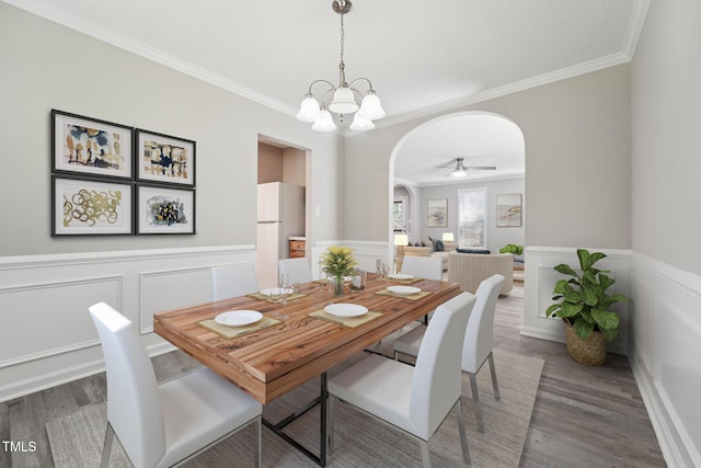 105 Leacroft Way, Durham, NC 27703 - dining space featuring arched walkways, crown molding, wood finished floors, wainscoting, and a ceiling fan