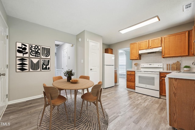 105 Leacroft Way, Durham, NC 27703 - kitchen featuring white appliances, under cabinet range hood, light wood-style floors, light countertops, and decorative backsplash