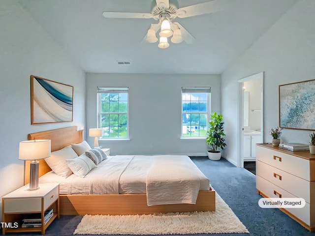 308 Quartz Dr, Durham, NC 27703 - bedroom with carpet flooring, vaulted ceiling, connected bathroom, and a ceiling fan
