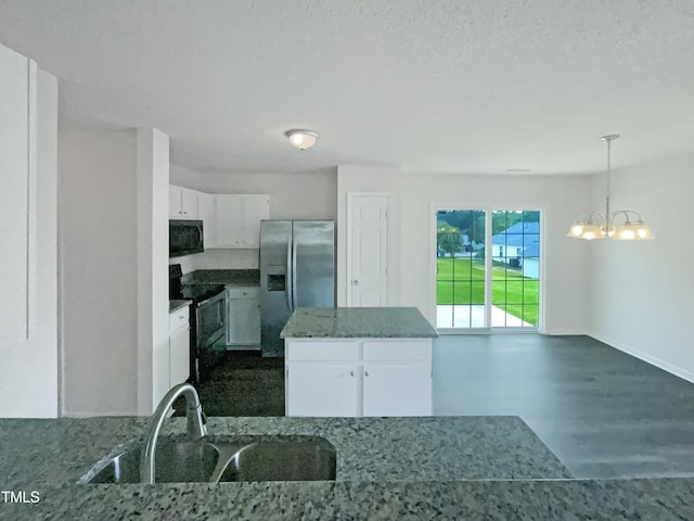308 Quartz Dr, Durham, NC 27703 - kitchen with black microwave, stainless steel fridge with ice dispenser, electric range, white cabinetry, and a chandelier