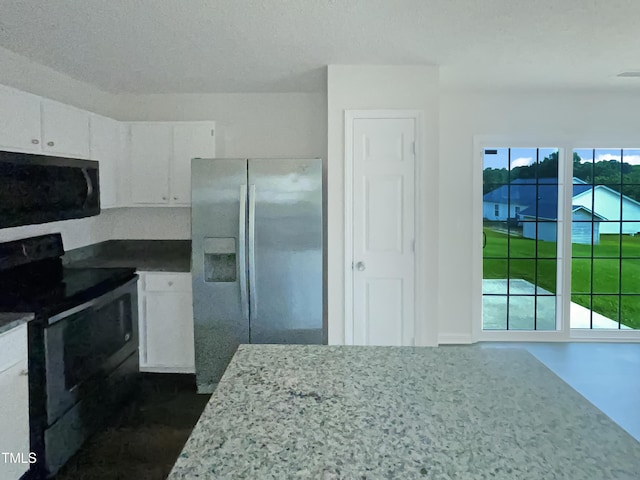 308 Quartz Dr, Durham, NC 27703 - kitchen with black range with electric cooktop, stainless steel fridge, and white cabinetry