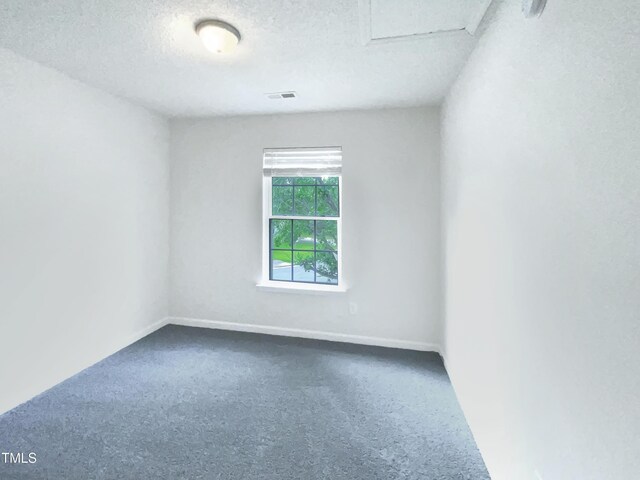 308 Quartz Dr, Durham, NC 27703 - spare room featuring dark colored carpet, a textured ceiling, and attic access