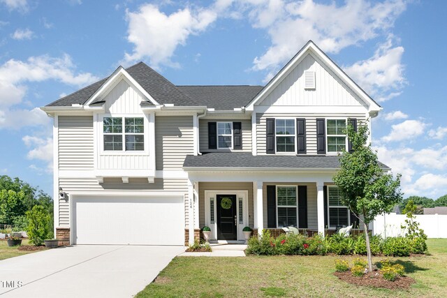 124 Airlie Place Ln, Willow Springs, NC 27592 - view of front facade featuring board and batten siding, concrete driveway, an attached garage, and covered porch