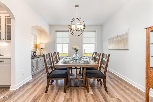 124 Airlie Place Ln, Willow Springs, NC 27592 - dining area featuring light wood finished floors, a chandelier, and arched walkways