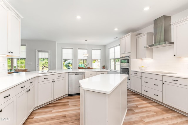 124 Airlie Place Ln, Willow Springs, NC 27592 - kitchen featuring stainless steel appliances, wall chimney range hood, light countertops, light wood finished floors, and recessed lighting