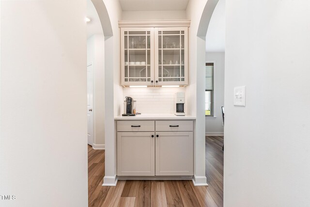 124 Airlie Place Ln, Willow Springs, NC 27592 - bar area with arched walkways, light wood-style floors, and backsplash