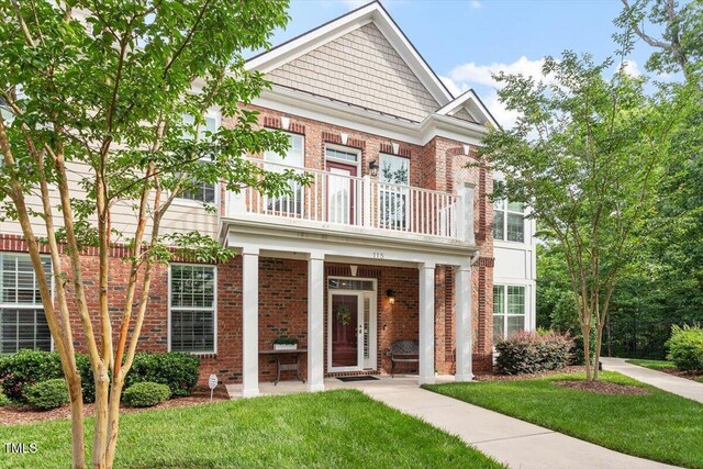 10310 Sablewood Dr Unit 115, Raleigh, NC 27617 - view of front facade with a balcony, brick siding, a front lawn, and covered porch