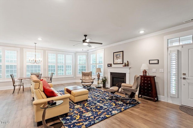 10310 Sablewood Dr Unit 115, Raleigh, NC 27617 - living area with ornamental molding, a ceiling fan, light wood-style floors, a glass covered fireplace, and a chandelier