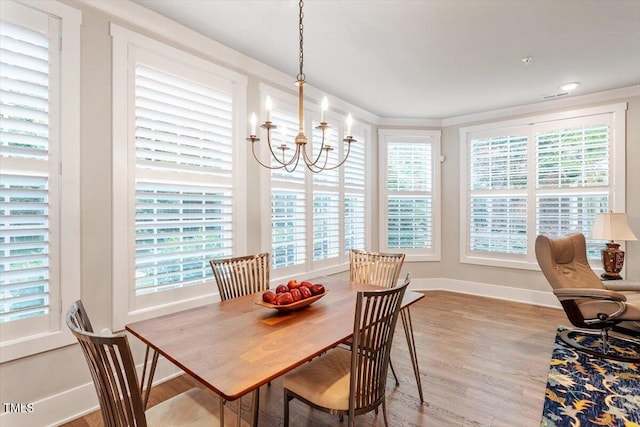 10310 Sablewood Dr Unit 115, Raleigh, NC 27617 - dining area featuring a chandelier, wood finished floors, and plenty of natural light