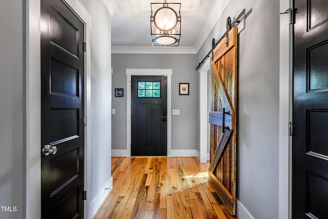 405 Culvert St, Apex, NC 27502 - foyer with a barn door, light wood finished floors, and crown molding