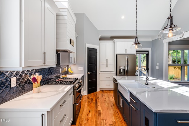 405 Culvert St, Apex, NC 27502 - kitchen with appliances with stainless steel finishes, light wood-type flooring, decorative backsplash, a center island with sink, and white cabinets