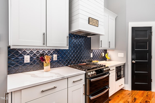 405 Culvert St, Apex, NC 27502 - kitchen featuring double oven range, built in microwave, custom range hood, white cabinetry, and light wood-type flooring