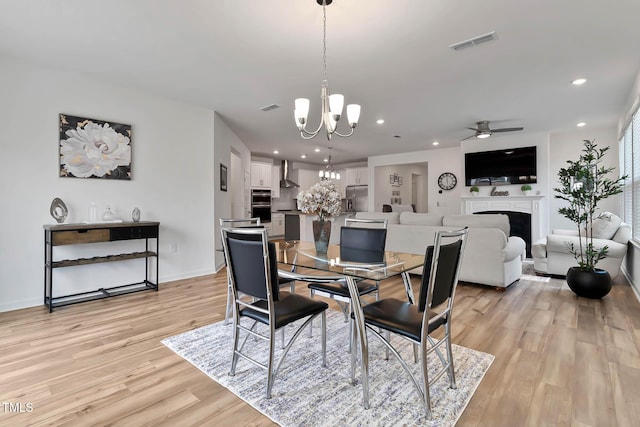 265 Purple Aster St, Youngsville, NC 27596 - dining room featuring a chandelier, light wood-type flooring, ceiling fan, a fireplace, and recessed lighting