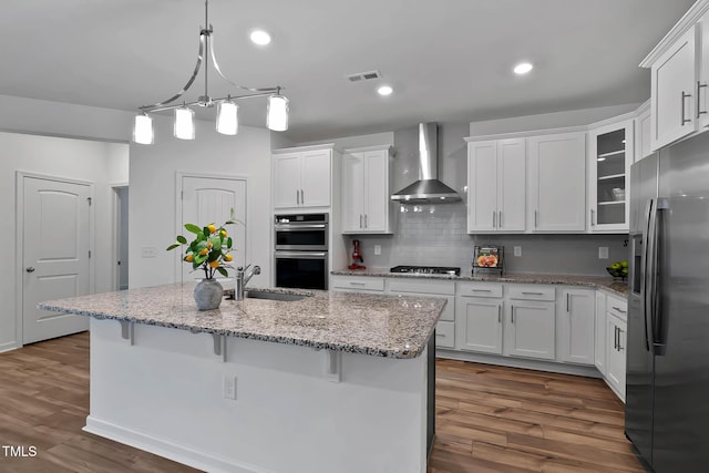 265 Purple Aster St, Youngsville, NC 27596 - kitchen with appliances with stainless steel finishes, wall chimney range hood, white cabinetry, dark wood finished floors, and a breakfast bar area