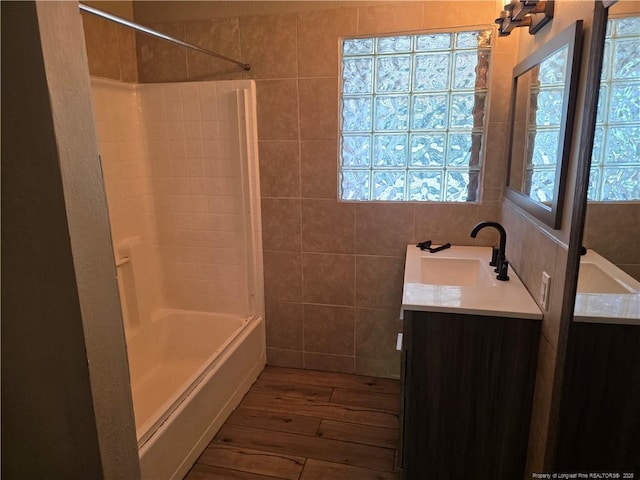4969 Arlington St, Hope Mills, NC 28348 - bathroom featuring double vanity, wood-type flooring,  shower combination, and tile walls