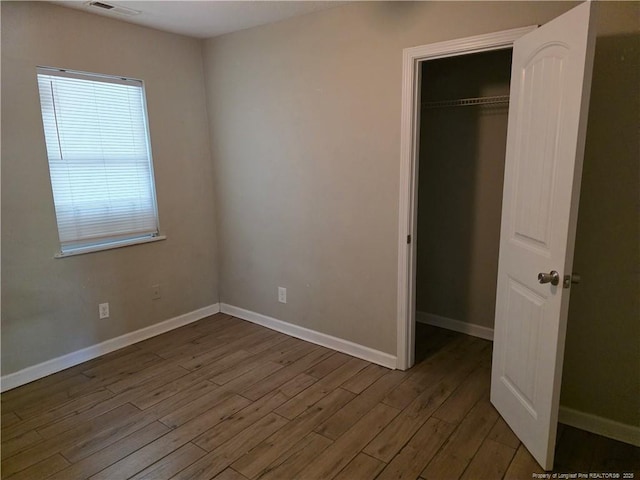 4969 Arlington St, Hope Mills, NC 28348 - unfurnished bedroom featuring wood finished floors, a closet, and a walk in closet
