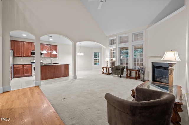 1040 Bellenden Dr, Durham, NC 27713 - living area featuring arched walkways, high vaulted ceiling, a premium fireplace, and a chandelier