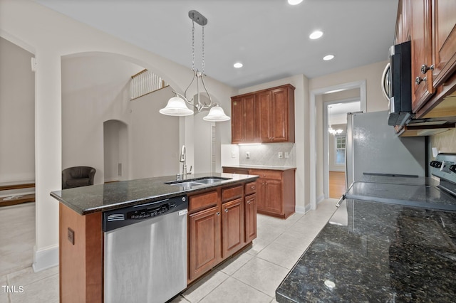 1040 Bellenden Dr, Durham, NC 27713 - kitchen featuring stainless steel appliances, arched walkways, light tile patterned floors, dark stone countertops, and decorative light fixtures