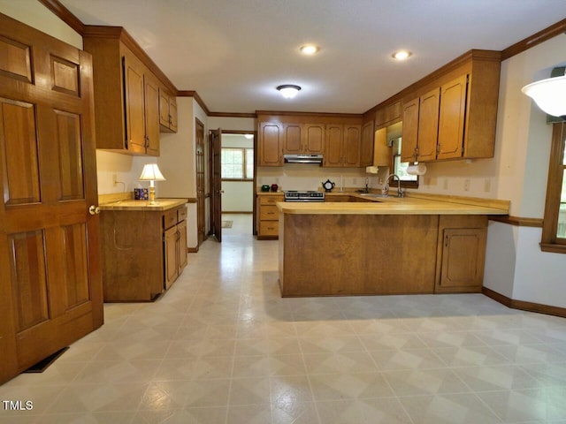 637 Shadywood Ln, Raleigh, NC 27603 - kitchen featuring exhaust hood, brown cabinetry, a peninsula, light countertops, and crown molding