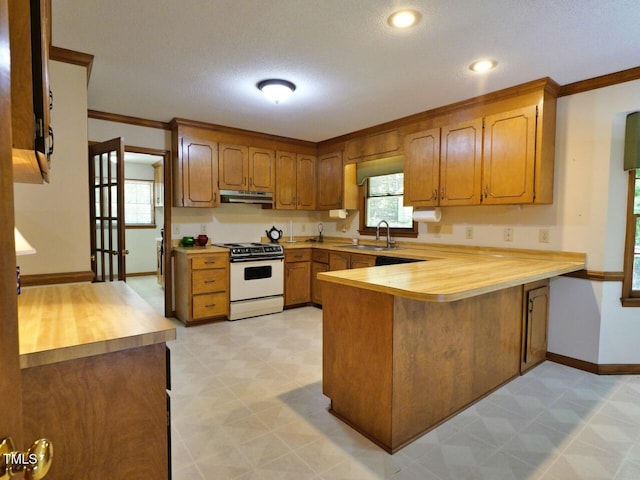 637 Shadywood Ln, Raleigh, NC 27603 - kitchen with white electric stove, under cabinet range hood, a peninsula, light flooring, and brown cabinets