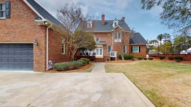 604 Hillcrest Pl, Goldsboro, NC 27534 - view of front facade featuring a chimney, brick siding, a front lawn, and a garage