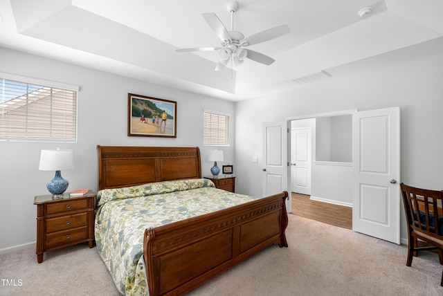 7117 Crested Iris Pl, Durham, NC 27703 - bedroom with light colored carpet, multiple windows, and a tray ceiling