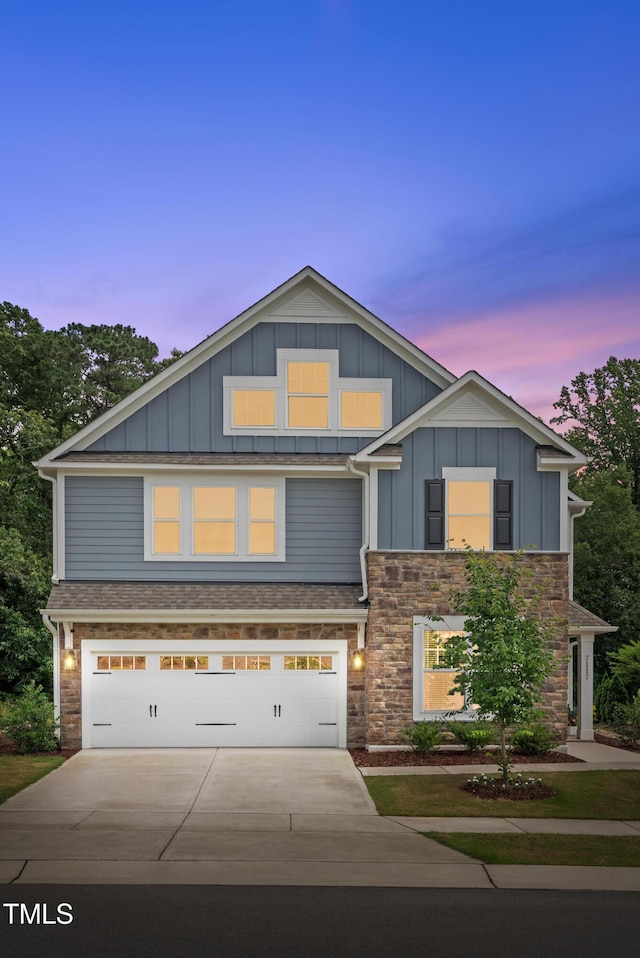 7117 Crested Iris Pl, Durham, NC 27703 - view of front of home featuring driveway, stone siding, board and batten siding, and a garage