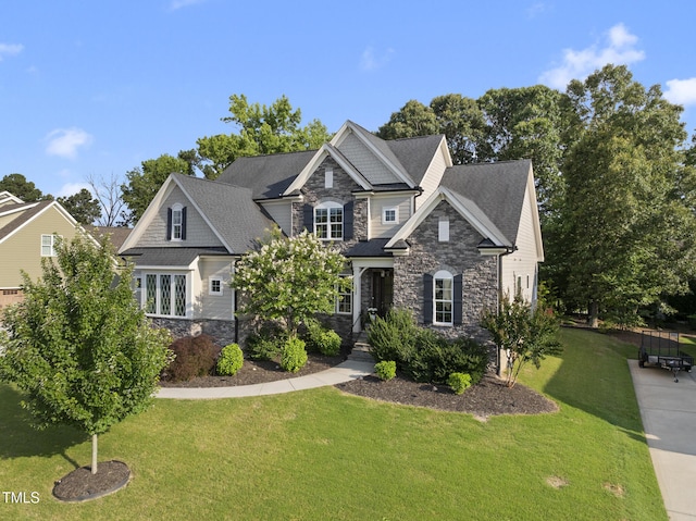1325 Mackinaw Dr, Wake Forest, NC 27587 - craftsman house with stone siding, a front yard, and roof with shingles