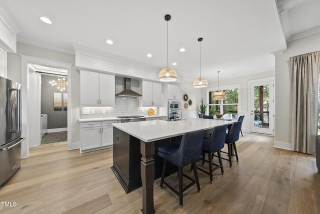 1325 Mackinaw Dr, Wake Forest, NC 27587 - kitchen featuring wall chimney exhaust hood, stainless steel appliances, light wood-style floors, light countertops, and recessed lighting
