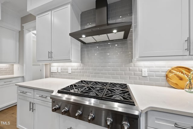 1325 Mackinaw Dr, Wake Forest, NC 27587 - kitchen featuring wall chimney range hood, stainless steel gas cooktop, decorative backsplash, white cabinetry, and wood finished floors