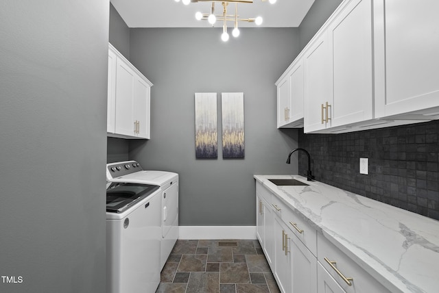 1325 Mackinaw Dr, Wake Forest, NC 27587 - laundry room with washer and dryer, cabinet space, dark stone finish flooring, and a chandelier
