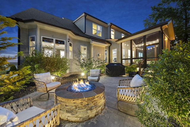 1325 Mackinaw Dr, Wake Forest, NC 27587 - patio at twilight with an outdoor fire pit, a grill, a patio area, and a sunroom