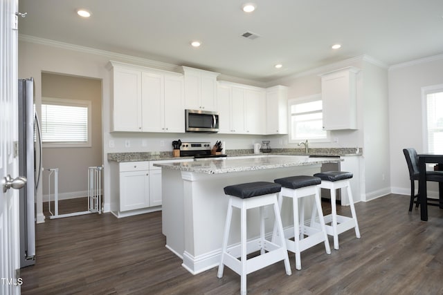 200 Sweet Violet Dr, Youngsville, NC 27596 - kitchen with stainless steel appliances, white cabinets, plenty of natural light, crown molding, and recessed lighting