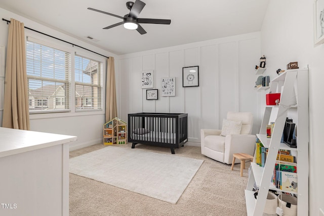 1020 Regency Cottage Pl, Cary, NC 27518 - carpeted bedroom with a nursery area, a decorative wall, and a ceiling fan