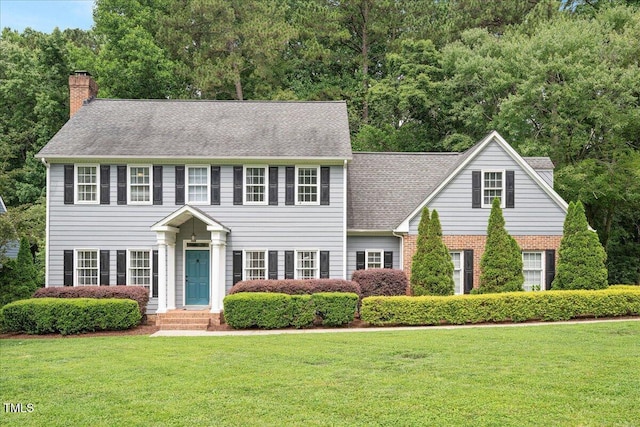 2008 Corberrie Ln, Raleigh, NC 27613 - colonial home with a chimney, a front lawn, roof with shingles, and brick siding