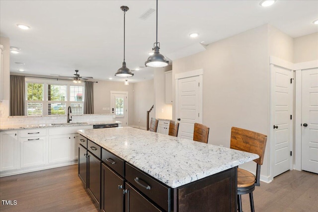 513 Brooks St, Wake Forest, NC 27587 - kitchen featuring white cabinets, wood finished floors, a ceiling fan, a breakfast bar, and a center island