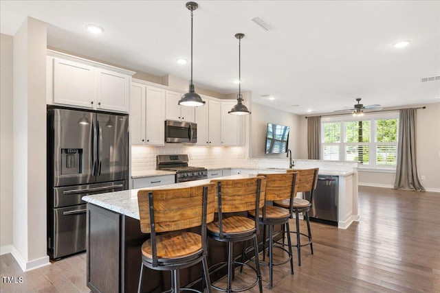 513 Brooks St, Wake Forest, NC 27587 - kitchen featuring stainless steel appliances, a peninsula, wood finished floors, decorative backsplash, and ceiling fan